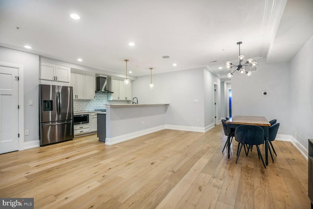 1317 Randolph St NW Unit 1, Washington, DC 20011 - kitchen featuring wall chimney range hood, appliances with stainless steel finishes, an inviting chandelier, recessed lighting, and backsplash