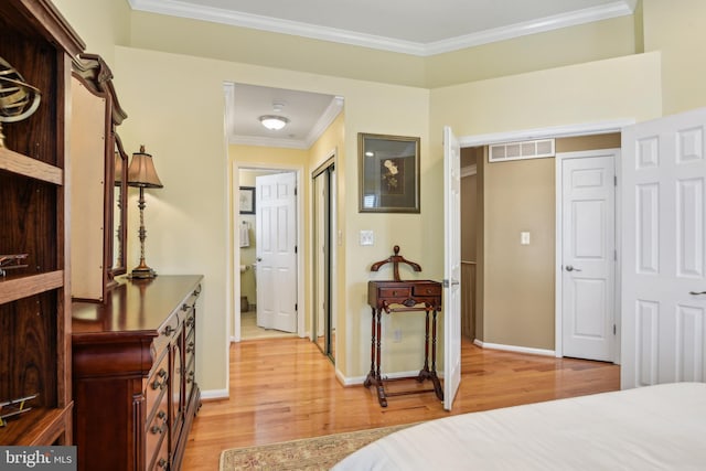 bedroom with baseboards, ornamental molding, and light wood finished floors