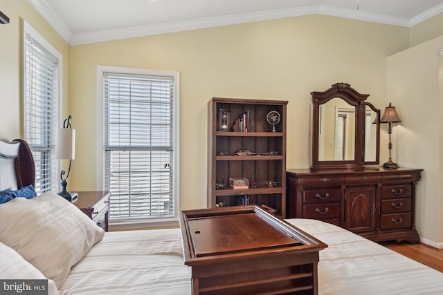 bedroom featuring multiple windows, vaulted ceiling, and wood finished floors