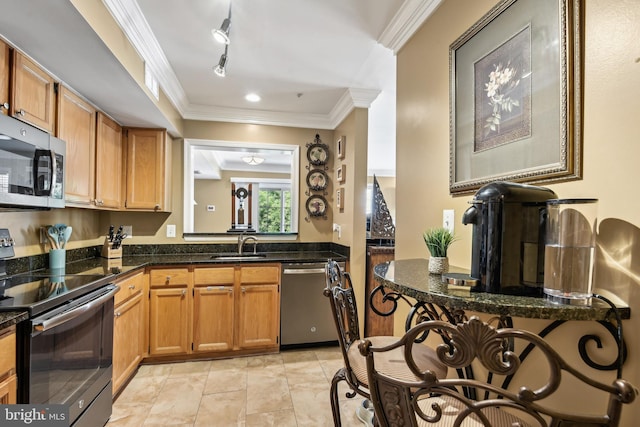 kitchen with crown molding, appliances with stainless steel finishes, dark stone counters, and a sink