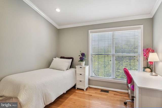 bedroom with crown molding, baseboards, visible vents, and light wood finished floors