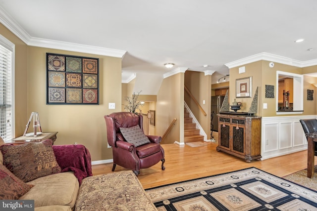 living area with ornamental molding and light wood-style floors