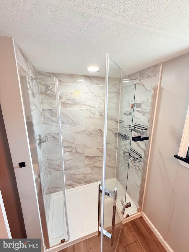 38 Clara St, Norristown, PA 19403 - full bath featuring wood finished floors, a marble finish shower, and a textured ceiling