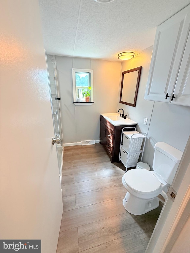 38 Clara St, Norristown, PA 19403 - bathroom with vanity, wood finished floors, a shower with shower door, and a textured ceiling