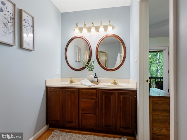 173 Riverside Dr, Harpers Ferry, WV 25425 - full bathroom with double vanity, wood finished floors, and baseboards