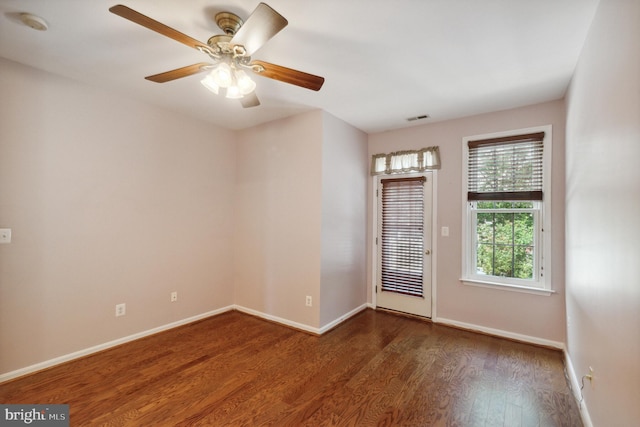 unfurnished room featuring visible vents, a ceiling fan, baseboards, and wood finished floors