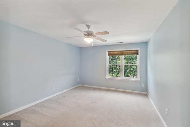 spare room featuring carpet floors, baseboards, visible vents, and ceiling fan