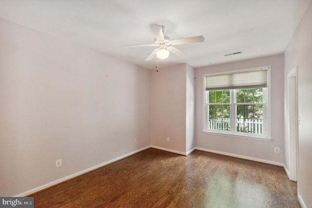 spare room with baseboards, a ceiling fan, wood finished floors, and visible vents