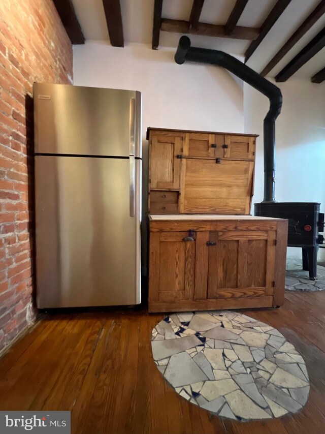 2102 E Dauphin St, Philadelphia, PA 19125 - kitchen featuring freestanding refrigerator, a wood stove, beam ceiling, dark wood-type flooring, and brown cabinetry
