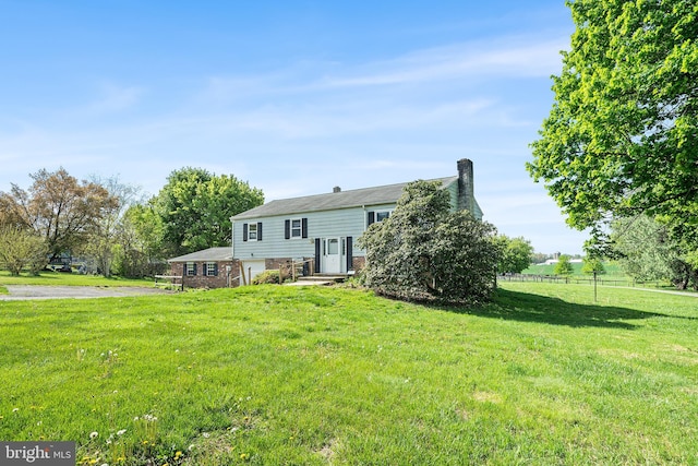 rear view of property with a yard