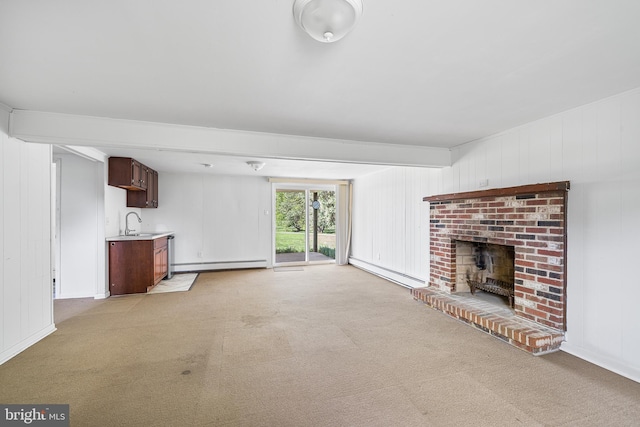 unfurnished living room with a sink, light carpet, a baseboard heating unit, and a brick fireplace