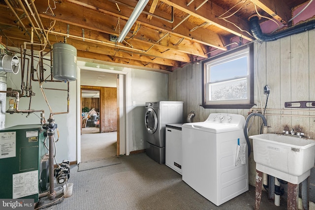 washroom with carpet flooring, laundry area, a sink, a heating unit, and washing machine and dryer