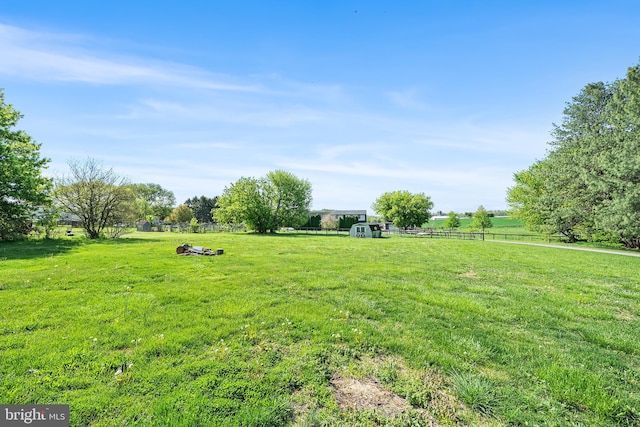 view of yard with fence and a rural view