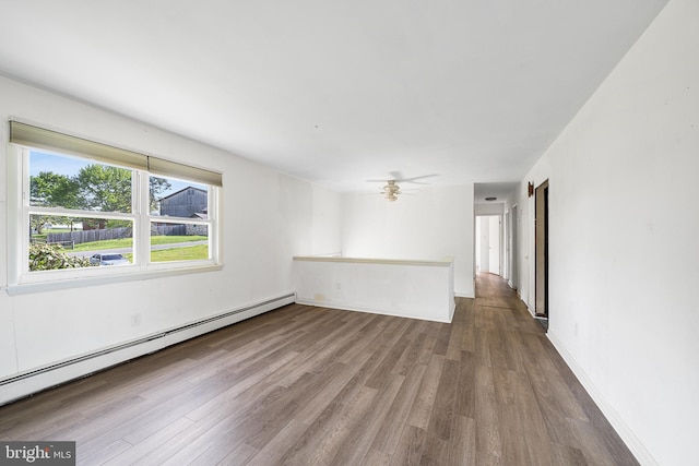 unfurnished room with ceiling fan, baseboards, a baseboard radiator, and wood finished floors