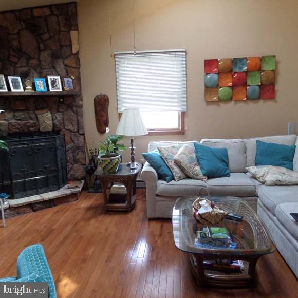 living area with a fireplace and wood-type flooring