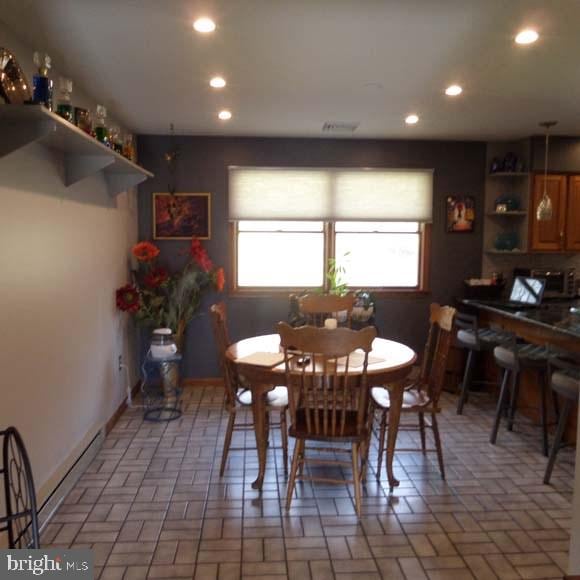 dining room featuring recessed lighting, visible vents, and brick floor