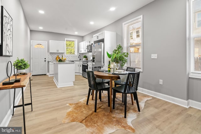 dining area with light wood-style floors, baseboards, and recessed lighting