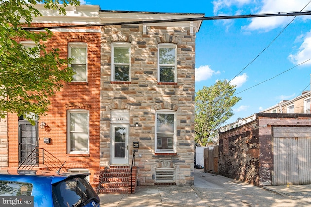 back of property with entry steps and stone siding