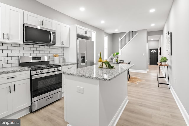 kitchen featuring appliances with stainless steel finishes, recessed lighting, light wood-style flooring, and white cabinetry