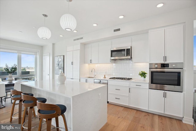 923 V St NW Unit 601, Washington, DC 20001 - kitchen featuring appliances with stainless steel finishes, decorative backsplash, white cabinetry, light countertops, and recessed lighting