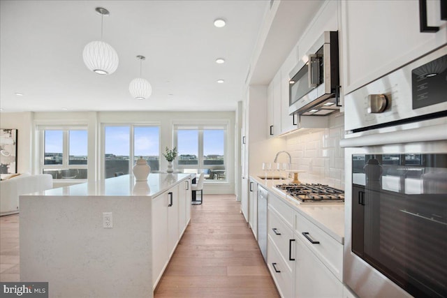 923 V St NW Unit 601, Washington, DC 20001 - kitchen featuring appliances with stainless steel finishes, tasteful backsplash, a center island, white cabinetry, and recessed lighting