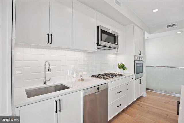923 V St NW Unit 601, Washington, DC 20001 - kitchen featuring stainless steel appliances, white cabinetry, light countertops, decorative backsplash, and recessed lighting
