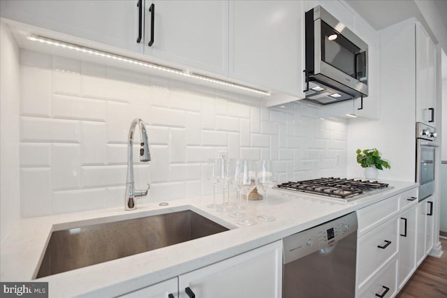 923 V St NW Unit 601, Washington, DC 20001 - kitchen featuring appliances with stainless steel finishes, white cabinetry, decorative backsplash, and light stone counters