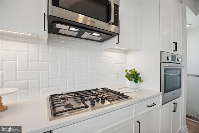 923 V St NW Unit 601, Washington, DC 20001 - kitchen featuring stainless steel appliances, white cabinets, light countertops, and decorative backsplash