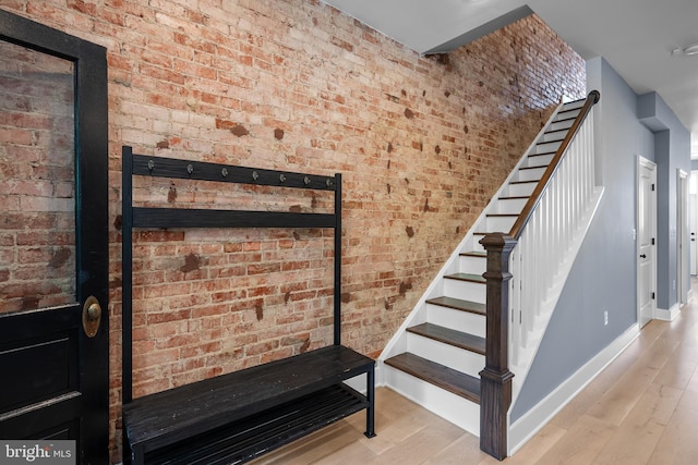 staircase featuring baseboards and wood finished floors