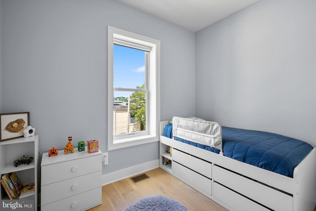 bedroom featuring light wood-style floors and baseboards