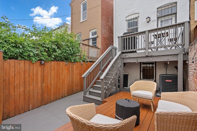 view of patio / terrace featuring central AC, fence, stairs, and a wooden deck
