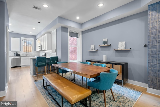 dining room featuring light wood-style flooring, recessed lighting, and baseboards