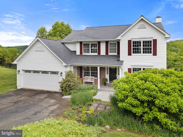 5722 Pond View Ln, Broad Run, VA 20137 - traditional-style home featuring covered porch, asphalt driveway, roof with shingles, a chimney, and an attached garage