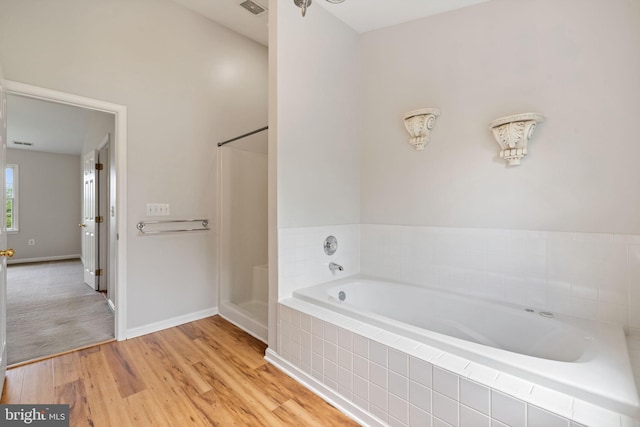 5722 Pond View Ln, Broad Run, VA 20137 - bathroom featuring a garden tub, wood finished floors, baseboards, and a shower