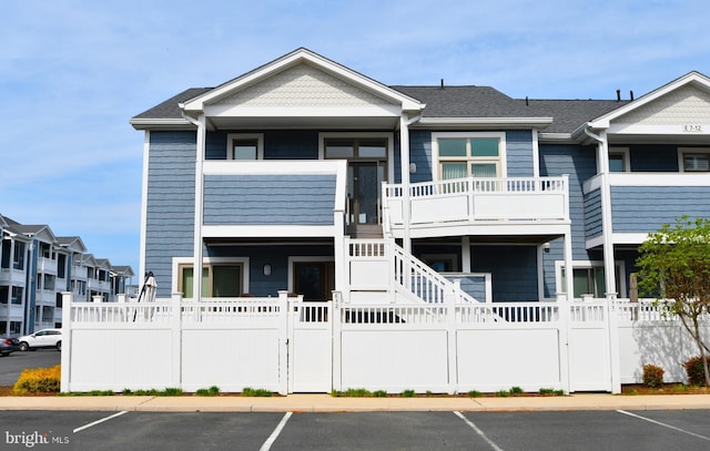 view of property featuring a fenced front yard, stairway, and uncovered parking