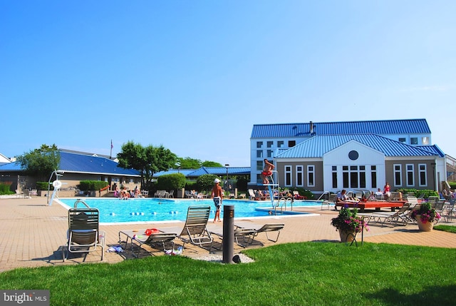community pool featuring a patio and a yard