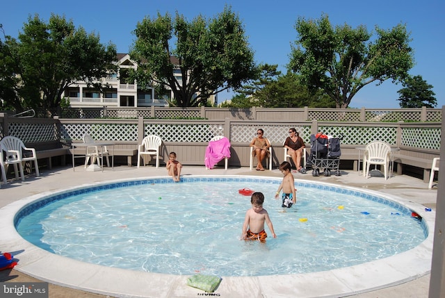view of swimming pool with a patio, fence, and a fenced in pool