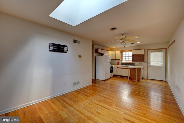unfurnished living room featuring ceiling fan, light wood finished floors, and baseboards