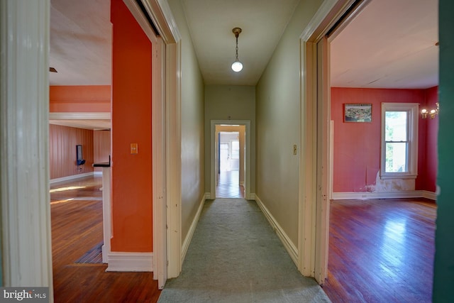 corridor with wood finished floors and baseboards