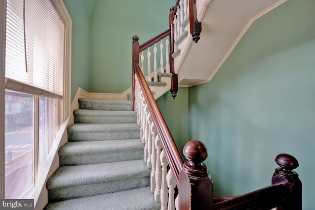 stairway with crown molding and vaulted ceiling