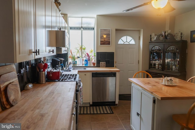kitchen with a ceiling fan, wooden counters, a sink, white cabinets, and appliances with stainless steel finishes