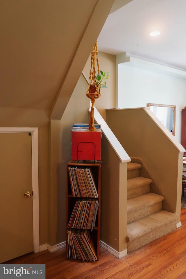 stairs with wood finished floors and baseboards