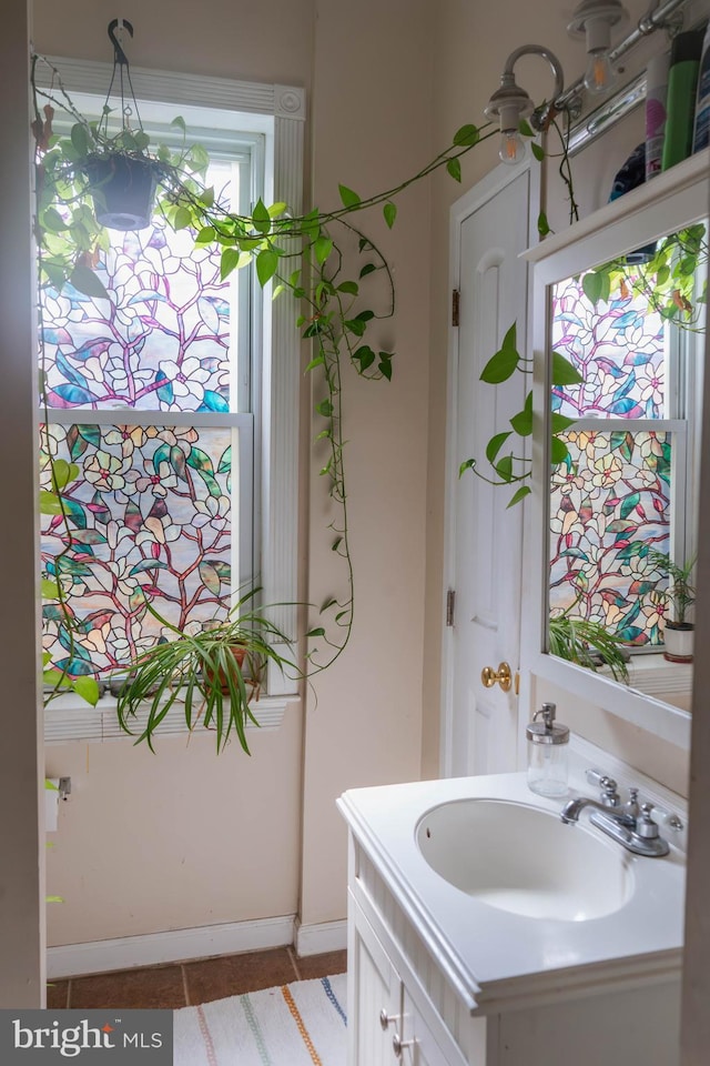 bathroom with baseboards, tile patterned floors, and vanity
