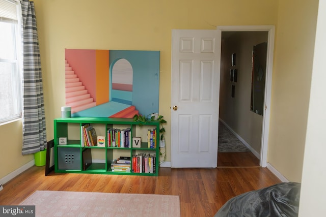 recreation room featuring wood finished floors and baseboards