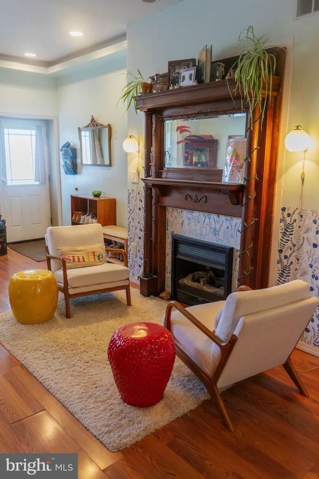 sitting room with visible vents, wood finished floors, a fireplace, and recessed lighting