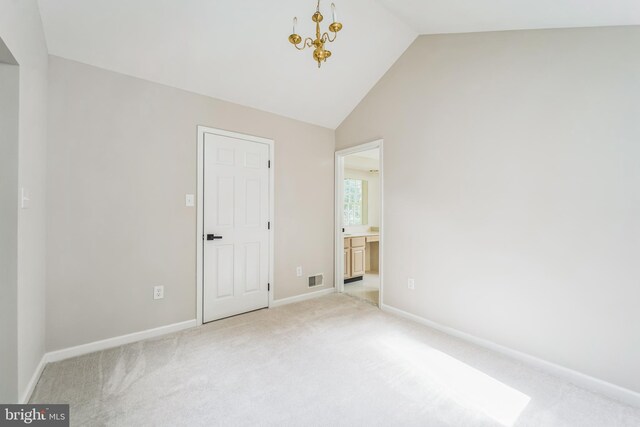 unfurnished bedroom with baseboards, visible vents, vaulted ceiling, and light colored carpet