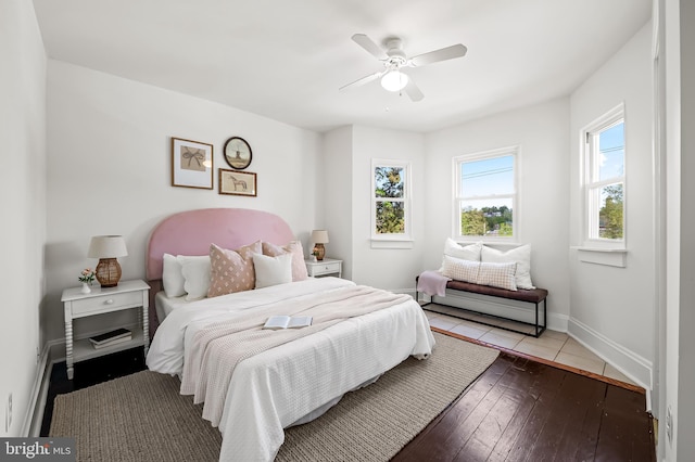 bedroom with baseboards, a ceiling fan, and wood-type flooring