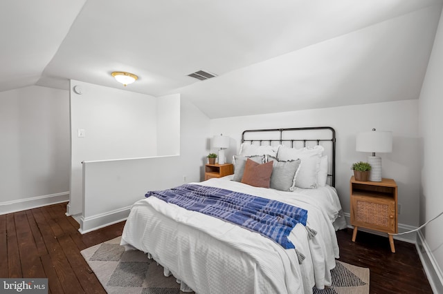 bedroom with wood-type flooring, baseboards, visible vents, and vaulted ceiling