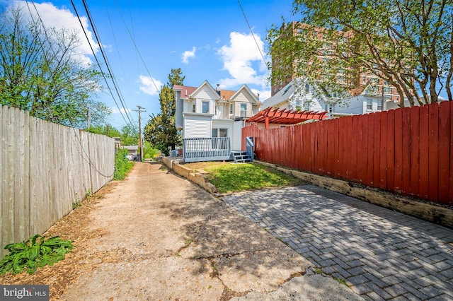 rear view of house with a fenced backyard, a pergola, and a patio area