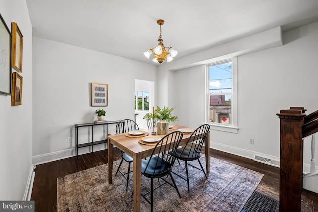 dining area featuring baseboards, dark wood-style flooring, a chandelier, and visible vents